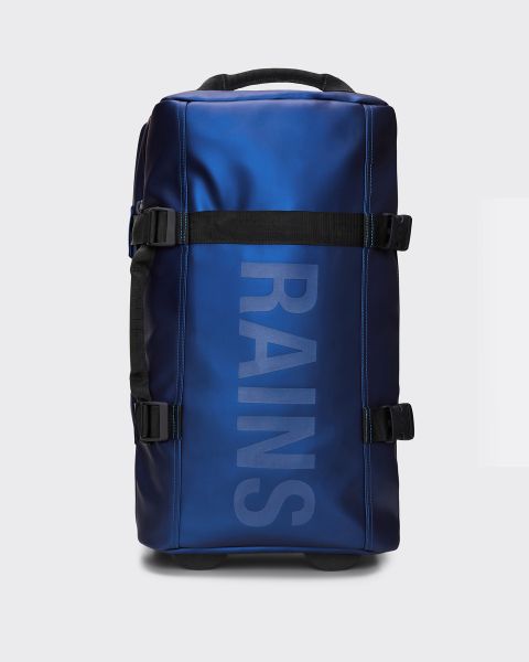 Un sac de voyage bleu rectangulaire avec l'inscription verticale "RAINS" sur le devant. Le sac a des sangles, des boucles et des roulettes noires sur le dessous et est conçu pour les voyages ou une utilisation en extérieur.