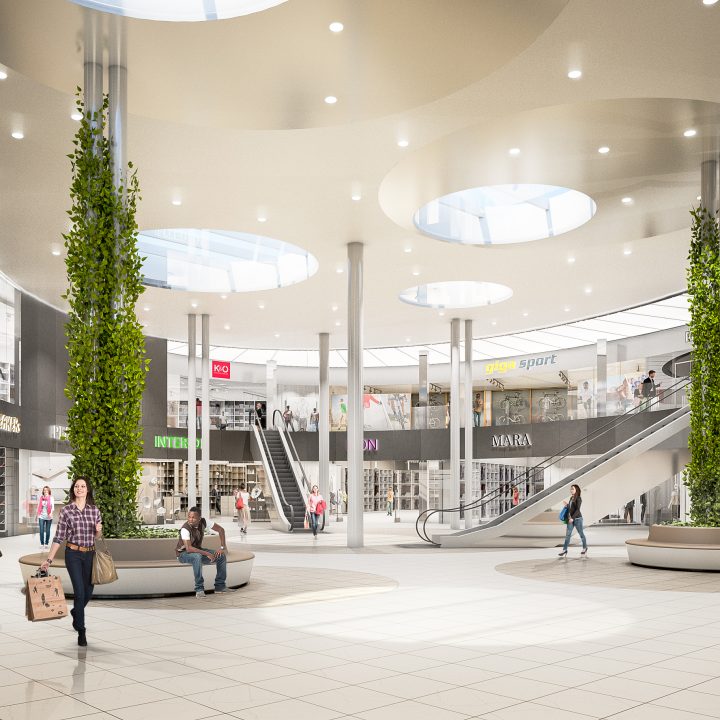 Un centre commercial spacieux et moderne avec de hauts plafonds et des lucarnes rondes. Des acheteurs se promènent et sont assis sur des bancs. Diverses enseignes de magasins, comme par exemple « SPAR », sont visibles. Deux piliers centraux sont entourés de verdure, ce qui ajoute une touche de nature.