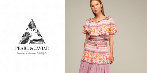 Une femme porte une robe à motifs roses et oranges et se tient devant un fond neutre. À sa gauche, on peut voir un logo représentant un triangle avec un motif de feuilles et le texte « PEARL & CAVIAR Style de vie de vacances de luxe ».