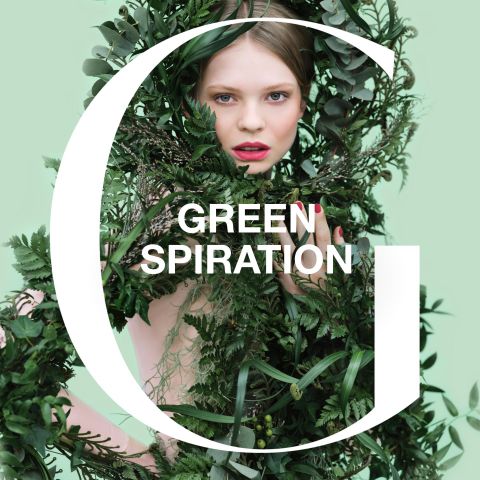 Une personne partiellement couverte de feuillage vert, avec un fond vert clair. Le mot « Green » est visible, tandis que « Spiration » est partiellement caché par les feuilles. Le design confère une esthétique naturelle et fraîche.
