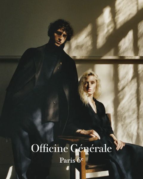Un homme et une femme en vêtements sombres et élégants posent dans une pièce doucement éclairée avec des ombres provenant d'une fenêtre. L'homme est debout et la femme est assise sur une chaise en bois. Le texte indique « Officine Générale Paris 6e ».