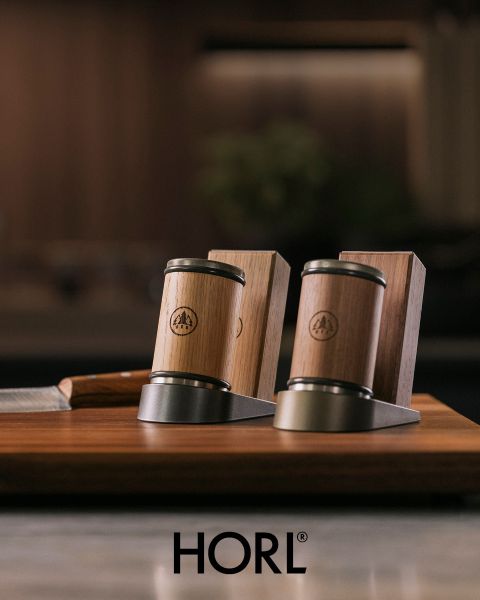 Deux aiguiseurs de couteaux en bois et métal, ainsi qu'un support de couteaux en bois sur une base en bois, avec le logo "HORL" en bas.