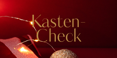 Une scène festive avec le texte "Kasten-Check" en or sur un fond rouge profond. Des lumières chaudes et un ornement doré scintillant créent une ambiance festive.