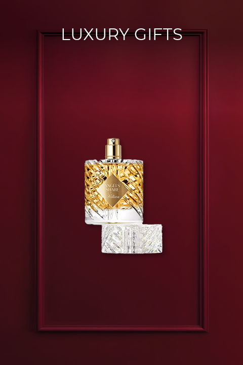 Sur un fond rouge profond, on aperçoit un flacon de parfum de luxe avec un design en or et en cristaux. En dessous se trouve le bouchon du flacon. Au-dessus, le texte « CADEAUX DE LUXE » est écrit en blanc.