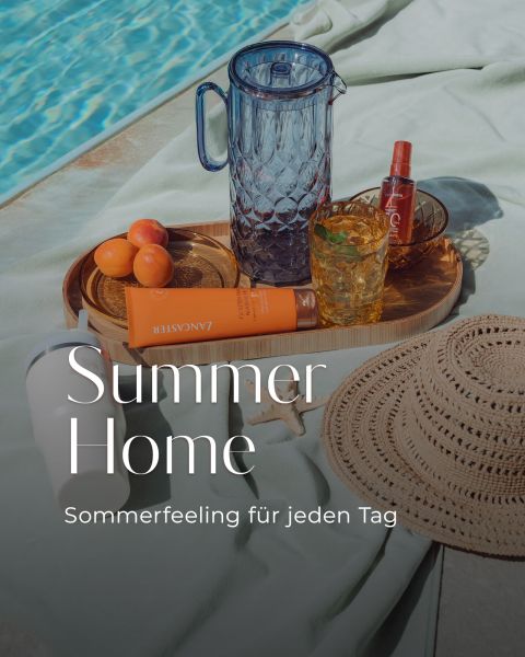 Une scène au bord de la piscine avec un chapeau de paille, de la crème solaire, des abricots, une carafe en verre, des boissons et un plateau. Le texte dit : "Summer Home - L'ambiance estivale au quotidien.