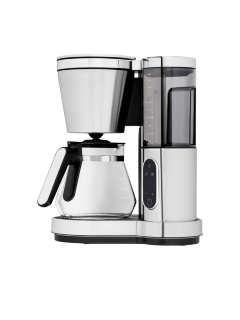 Une cafetière filtre moderne en acier inoxydable avec verseuse en verre, réservoir d'eau et panneau de commande, représentée sur fond blanc.