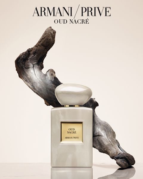 Un arrangement de neuf flacons de parfum Armani/Privé avec des bouchons de couleurs différentes, disposés en trois rangées devant un fond clair. Le texte en dessous indique "Armani/Privé Haute Couture Fragrances".