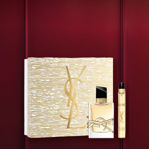 Coffret cadeau de parfum dans un cadre rouge foncé avec une boîte à motifs floraux, un petit flacon de parfum et un tube blanc avec un bouchon doré. En haut, il est écrit « Coffrets de parfums » en blanc.