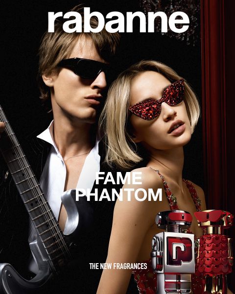 Deux flacons du parfum Rabanne Olympéa ABSOLU, un noir et un rose, sont présentés devant une fleur blanche épanouie sur un fond sombre. Le texte indique : « Rabanne OLYMPÉA ABSOLU - LE NOUVEAU PARFUM. ».