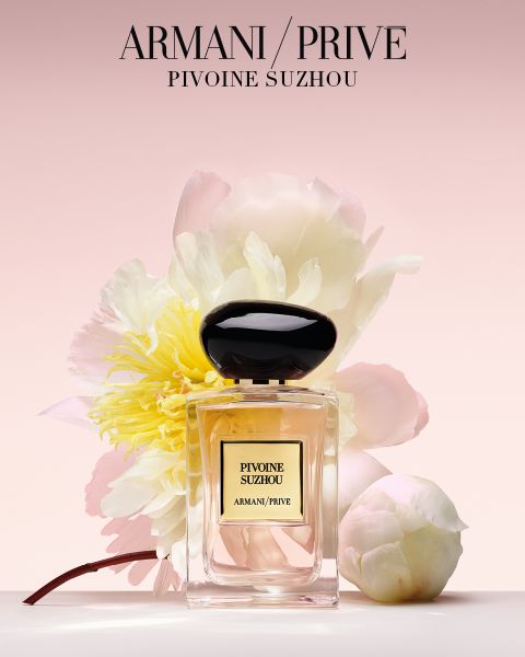 Un arrangement de neuf flacons de parfum Armani/Privé avec des bouchons de couleurs différentes, disposés en trois rangées devant un fond clair. Le texte en dessous indique "Armani/Privé Haute Couture Fragrances".