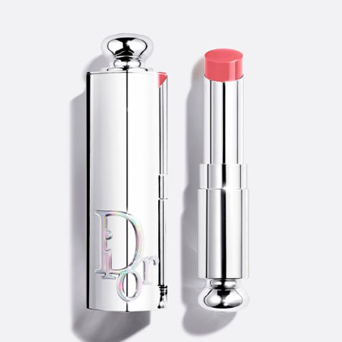 Un flacon de fond de teint Dior avec un bouchon noir et l'inscription "DIOR" verticalement sur le devant, photographié sur un fond clair.