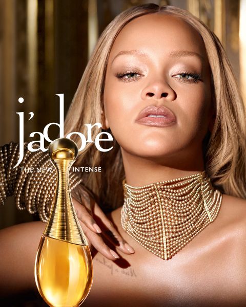 Une femme aux cheveux blonds tient trois flacons de parfum Dior Addict dans des tons orange, rose et violet, avec le texte "DIOR ADDICT THE NEW PERFUMES".