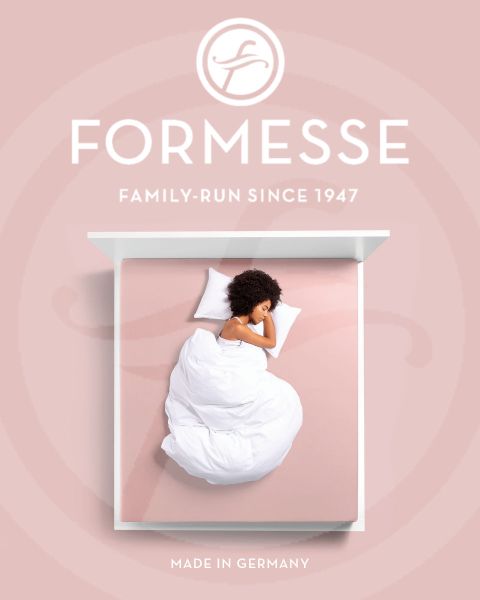 Une femme aux cheveux blonds dort sur le côté sur un lit bleu clair. Sa tête repose sur un oreiller blanc. Au bas de l'image, on peut voir l'inscription "Formesse" et un logo.