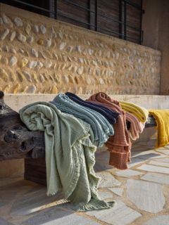 Quatre coussins rectangulaires vert olive avec un bord à froufrous discret sont disposés en deux rangées devant un fond avec un dégradé de couleurs gris et blanc.