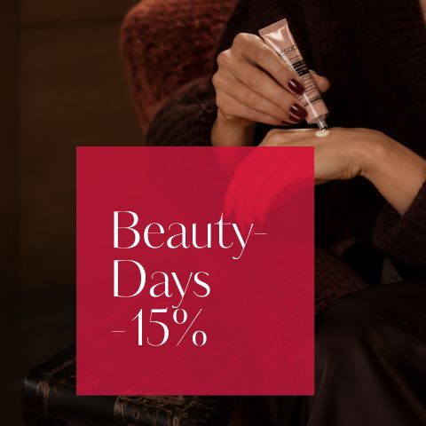 Une personne se crème la main, à côté d'elle se trouve une boîte rouge avec l'inscription : « Beauty-Sale - 15 % ».