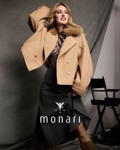 Une femme vêtue d'une cape en fausse fourrure sur un haut à imprimé léopard et une jupe marron est assise et pose ; en bas, on peut voir « monari » et le logo.