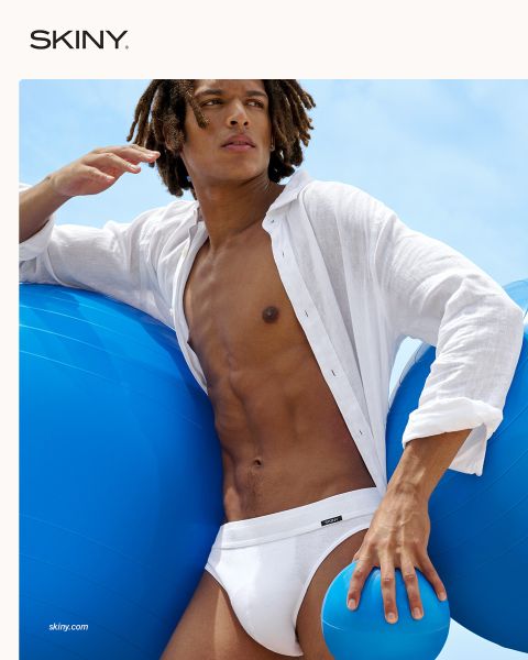 Un homme musclé et décontracté regarde vers le bas. Il porte un pull rouge sur l'épaule et a des sous-vêtements verts. Le fond est rouge foncé et le mot "SKINY" apparaît en bas.