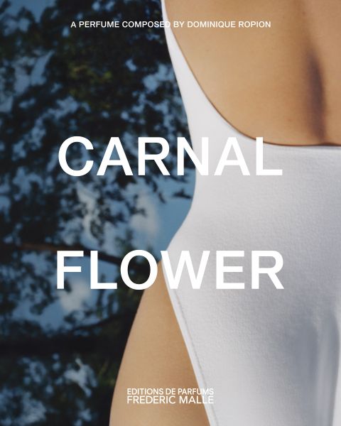 Gros plan d'une personne en maillot de bain blanc, avec des arbres flous en arrière-plan. Un grand texte au-dessus de l'image indique "CARNAL FLOWER". Le texte mentionne également Dominique Ropion et Editions de Parfums Frederic Malle.