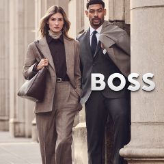 Une femme en tailleur beige et un homme en costume gris se tiennent à côté du logo BOSS.