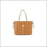 Hellbraune MCM-Tasche mit zwei Henkeln, verziert mit dem MCM-Monogramm-Logo und einer goldenen Logoplakette auf der Vorderseite vor weißem Hintergrund.