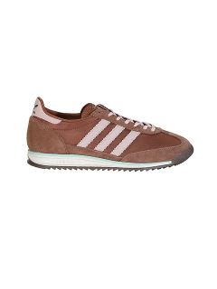 Sneaker marron en daim avec rayures blanches, languette arrière blanche et semelle en caoutchouc texturée, en vue de profil latéral sur fond blanc.