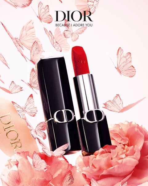 Un rouge à lèvres Dior rouge dans un étui noir et argent, entouré de papillons roses, de fleurs et d'un ruban avec le logo Dior.