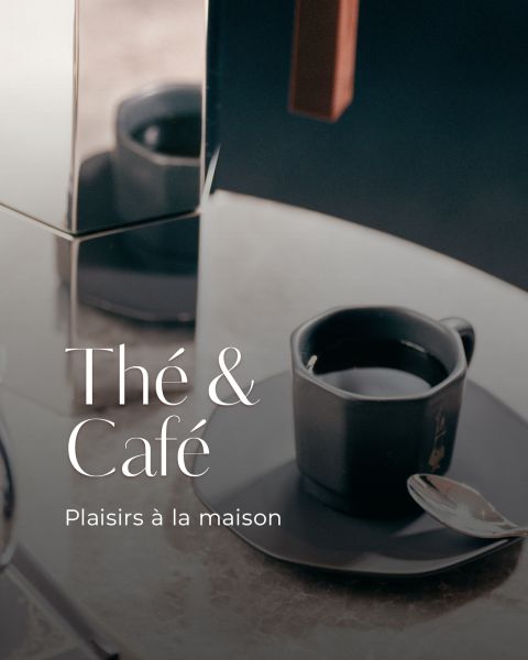 Café noir dans une tasse noire moderne sur une soucoupe avec une cuillère, à côté d'une surface réfléchissante. Le texte est le suivant : « Thé & Café. Plaisirs à la maison. »