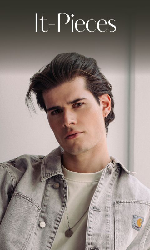 Un jeune homme aux cheveux coiffés, portant une veste en jean claire et une chemise blanche, regardant la caméra sous le texte "It-Pieces".