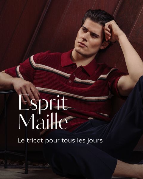 Un homme en polo en maille à rayures rouges est assis pensivement contre un mur portant l'inscription "Esprit Maille : Le tricot pour tous les jours.