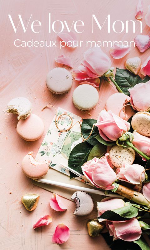 Roses roses, macarons pastel et chocolats emballés dans de l'or sur une surface rose avec une carte de fleurs. Texte : "Nous aimons maman. Cadeaux pour maman."