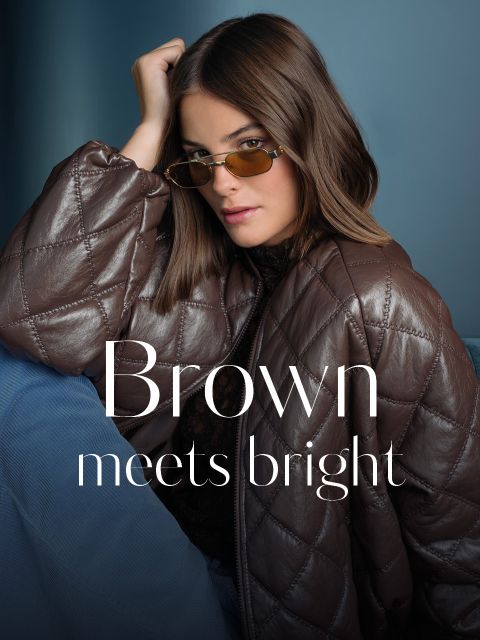 Une femme avec des lunettes teintées et une doudoune marron est assise devant un fond bleu. Le texte dit : « Le marron rencontre les couleurs fluo. ».