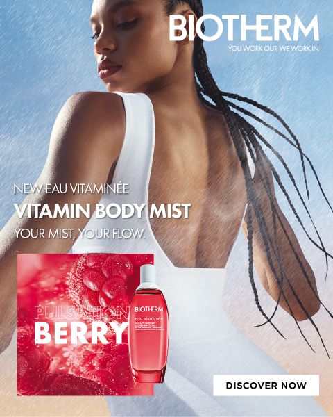 Une femme vêtue de blanc se tient dos à la caméra dans le brouillard. On peut voir une bouteille de « Biotherm Vitamin Body Mist » ; le texte fait la promotion du parfum « Pulsation Berry ».