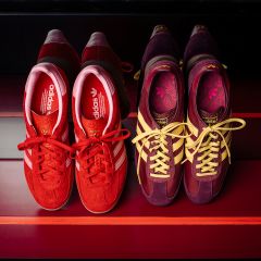 Deux paires de baskets Adidas : une paire rouge à rayures blanches et une paire violette et jaune, toutes deux sur un fond rayé rouge, vues de dessus.