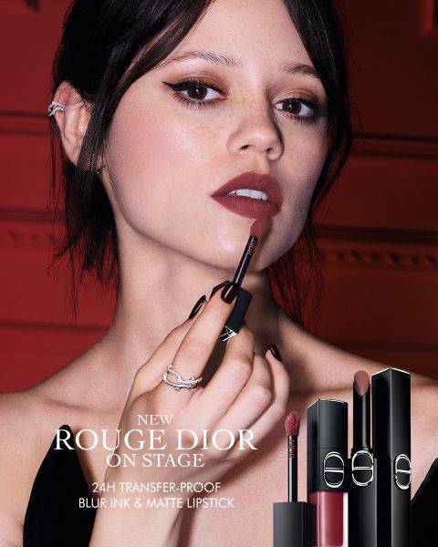 Une femme applique le rouge à lèvres « Rouge Dior » et tient l'applicateur près de ses lèvres. Trois étuis de rouge à lèvres sont représentés. Le texte fait la promotion d'un rouge à lèvres 24 heures, sans transfert, qui estompe les lèvres en douceur et offre un fini mat.