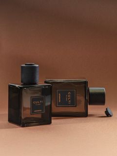 Deux flacons de parfum carrés en verre foncé avec l'inscription « CULTI MILANO ARAMARA » sur fond marron ; l'un est debout, l'autre est couché sur le côté.