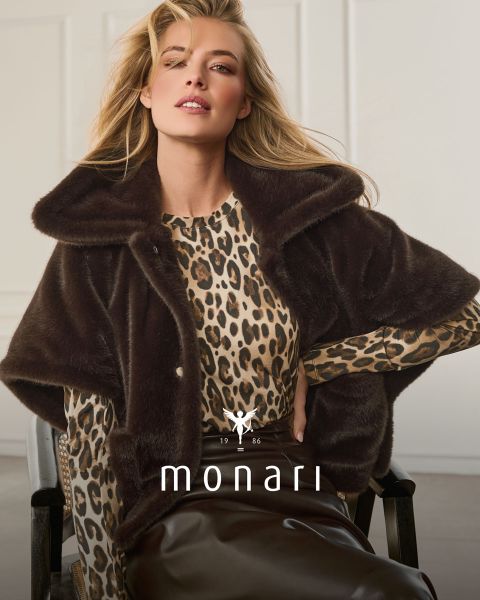 Une femme vêtue d'une cape en fausse fourrure sur un haut à imprimé léopard et une jupe marron est assise et pose ; en bas, on peut voir « monari » et le logo.