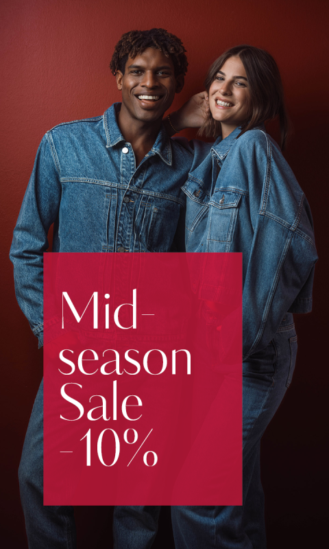 Deux personnes en tenue en jean sourient devant un mur rouge. L'image dit : « Vente de mi-saison - 10 % ».